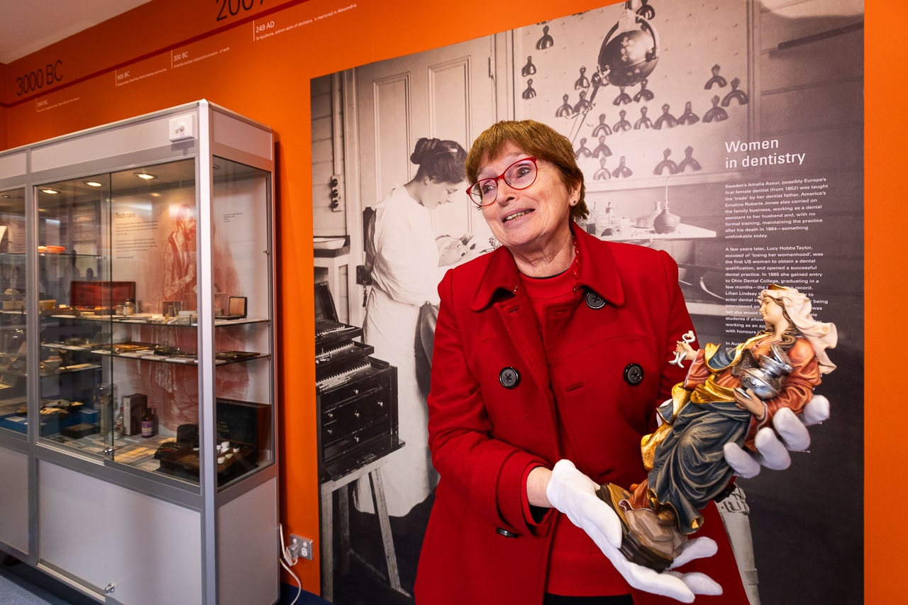 Dr Jacqueline Healy, Director Faculty Museums, Faculty of Medicine, Denistry and Health Sciences holding statue of Apollonia in the Henry Forman Atkinson Museum
