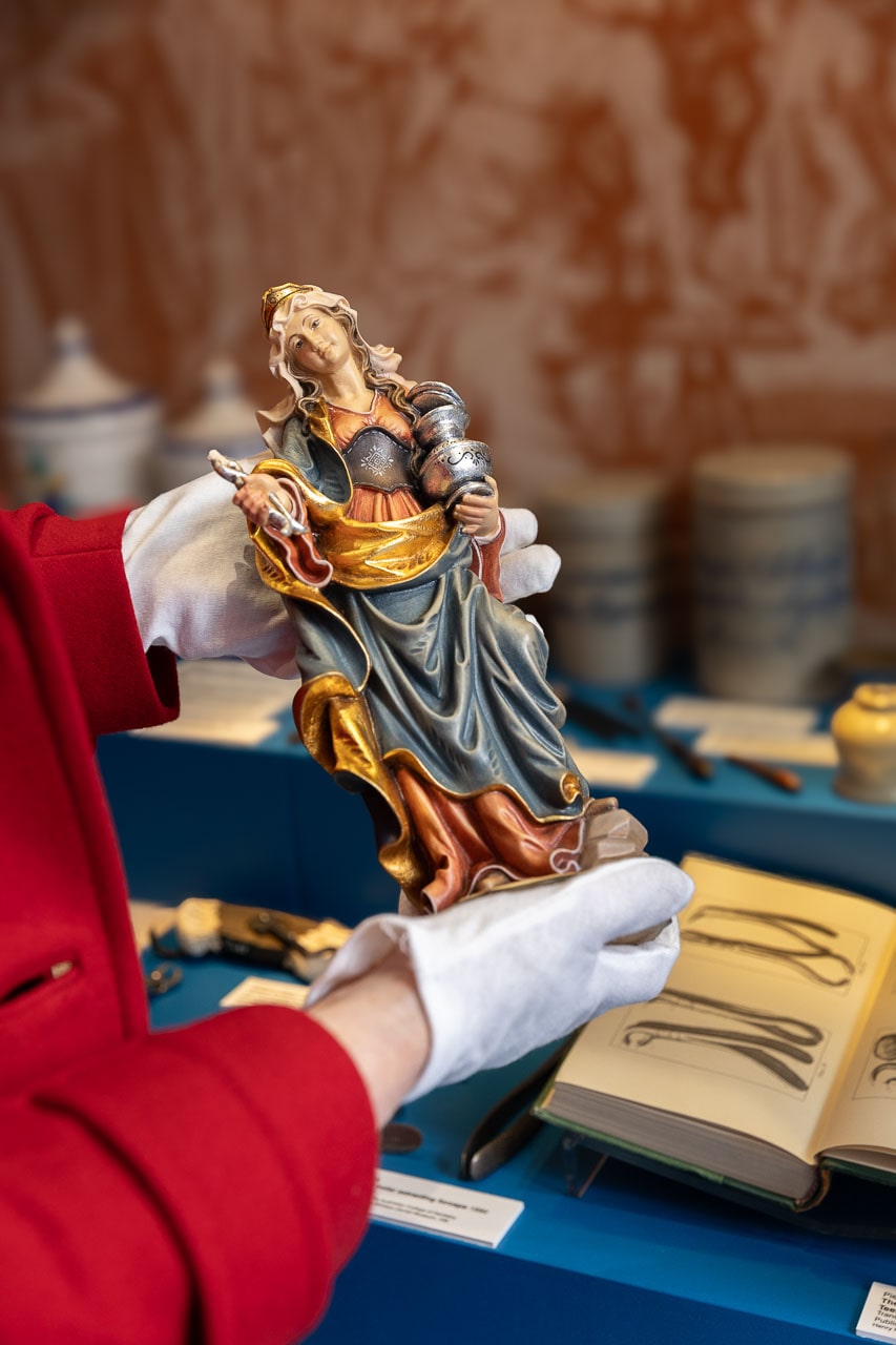 A close-up image of Dr Jacqueline Healy, Director Faculty Museums, Medicine, Denistry and Health Sciences holding statue of Apollonia the Patron Saint of Dentists